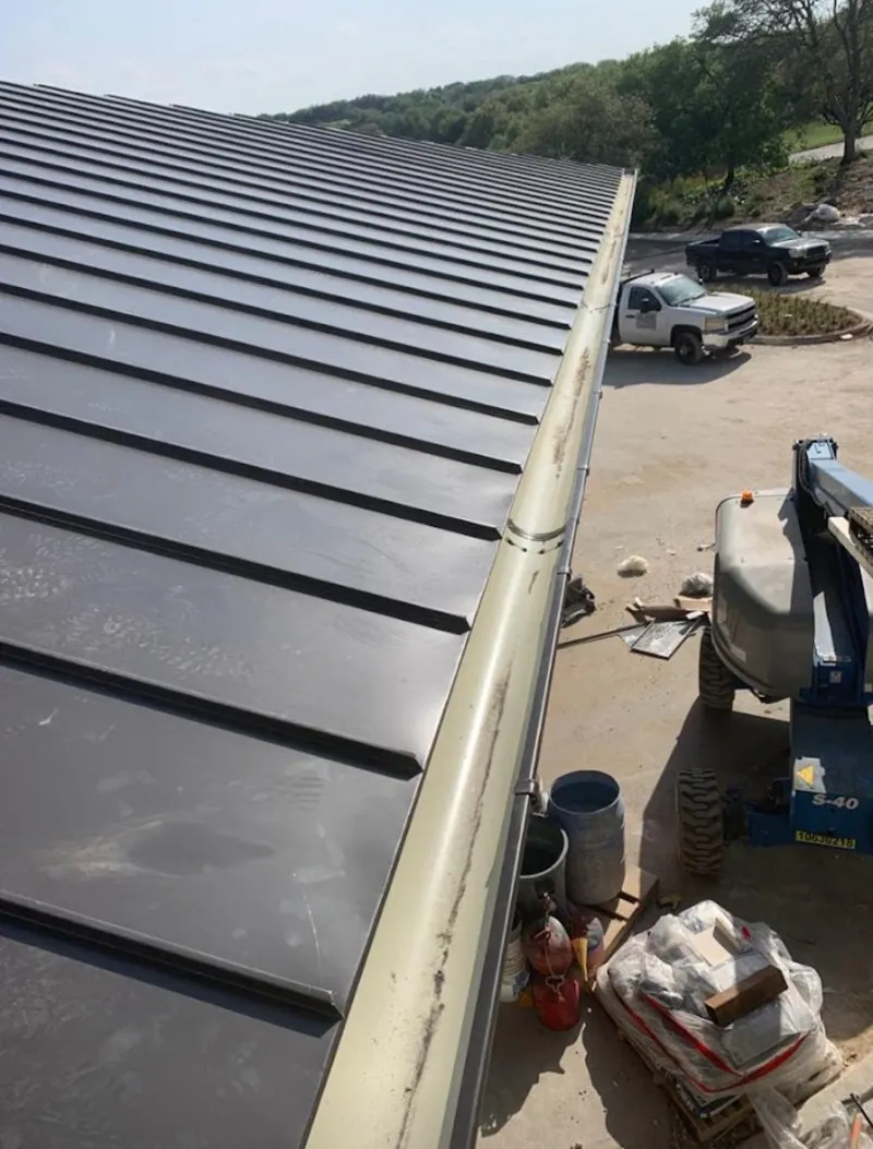 Standing seam panel and gutter detail on a metal roofing jobsite in Carmichael